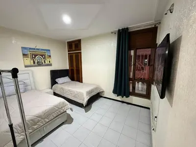 a small room with two beds and a window at Jawhara Jacobs apartment in Fès