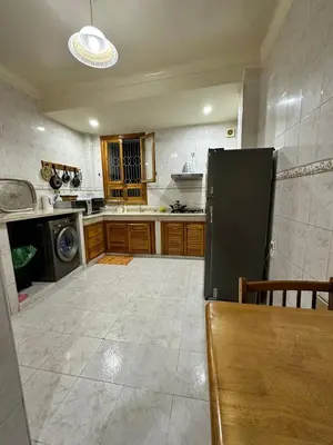 a large kitchen with a black refrigerator in it at Jawhara Jacobs apartment in Fès