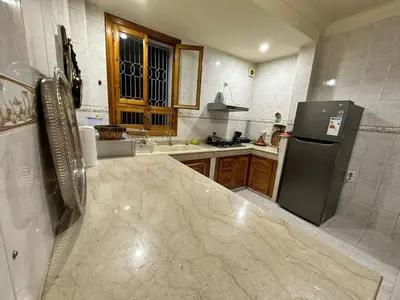 a kitchen with a refrigerator and a counter top at Jawhara Jacobs apartment in Fès