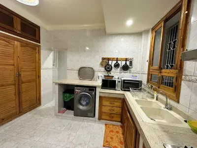 a kitchen with a sink and a washing machine at Jawhara Jacobs apartment in Fès