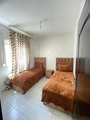 a bedroom with two beds and a window at Oued fes hay molay driss in Fès