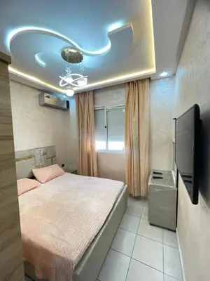 a bedroom with a bed and a flat screen tv at Oued fes hay molay driss in Fès