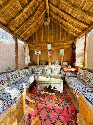 a large living room with couches and a rug at Riad Soleil du Monde in Zagora