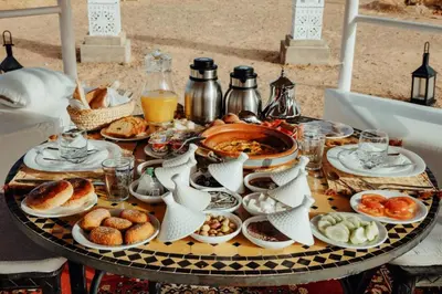 a table with plates of food on top of it at Sky View Camp in Merzouga