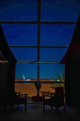 a room with a view of the beach at night at Sky View Camp in Merzouga