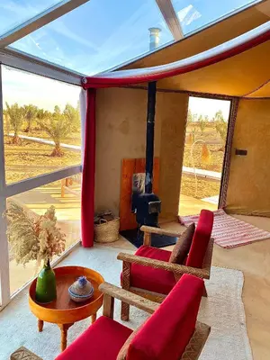 a living room with a red couch and a table at Sky View Camp in Merzouga