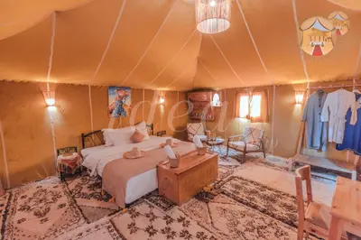 a bedroom with a bed in a tent at ideal desert camp in Merzouga