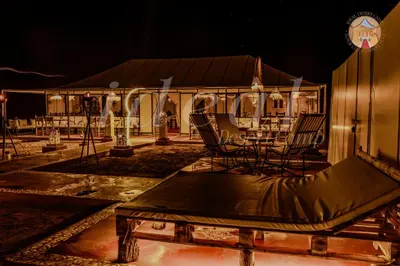 a stage with chairs and a table at night at ideal desert camp in Merzouga