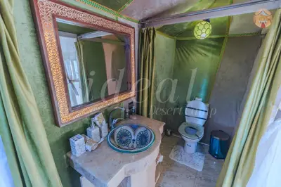 a bathroom with a sink and a mirror and a toilet at ideal desert camp in Merzouga
