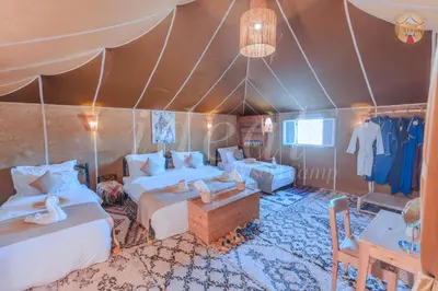 a bedroom with two beds in a tent at ideal desert camp in Merzouga