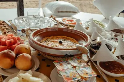 a table topped with food and a bowl of food at ideal desert camp in Merzouga