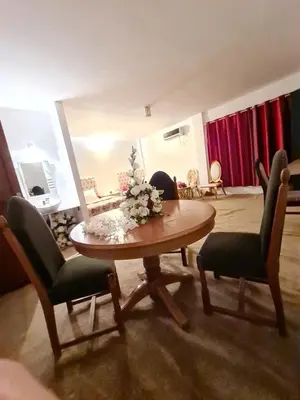 a living room with a wooden table and chairs at Hôtel et Restaurant ARIJ in Midelt