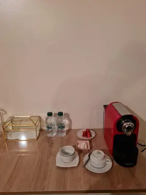 a table with a toaster and two plates and water bottles at Hôtel et Restaurant ARIJ in Midelt
