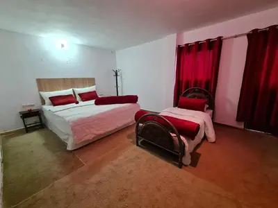 a bedroom with two beds and red curtains at Hôtel et Restaurant ARIJ in Midelt