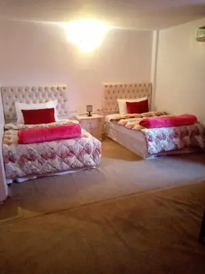 two beds sitting in a room with at Hôtel et Restaurant ARIJ in Midelt