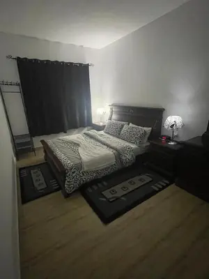 a bedroom with a bed and two tables and a mirror at Ferme Jnan Al Yassmine in Taza
