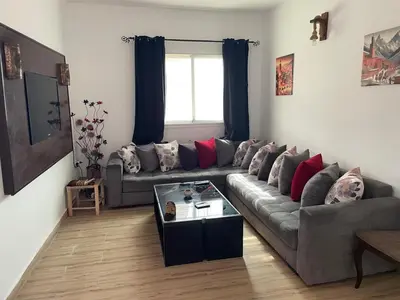 a living room with a gray couch and a window at Ferme Jnan Al Yassmine in Taza