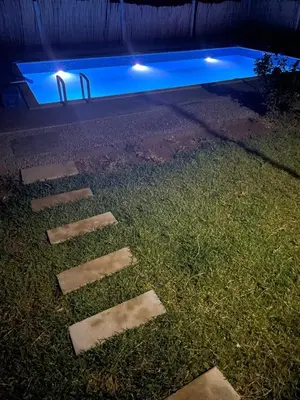 a swimming pool at night with rocks in the grass at Ferme Jnan Al Yassmine in Taza