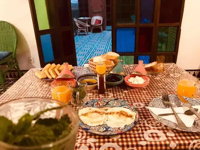 a table topped with plates of food and orange juice at Riad Alfredo in Fès