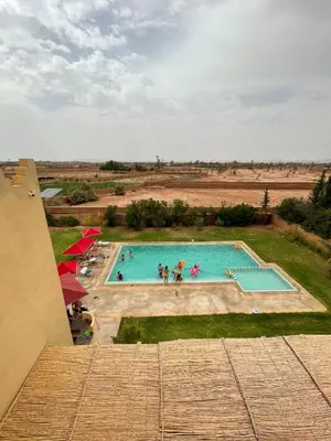 an overhead view of a swimming pool with people in it at Dar Amali, villa spacieuse 9ch avec piscine en exclusivité in Marrakech
