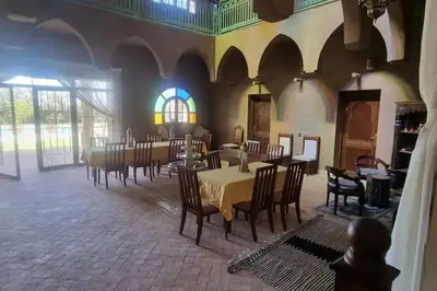 a dining room with tables and chairs in a building at Dar Amali, villa spacieuse 9ch avec piscine en exclusivité in Marrakech