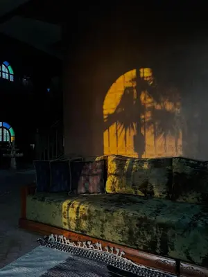 a couch sitting in a room with a shadow on a wall at Dar Amali, villa spacieuse 9ch avec piscine en exclusivité in Marrakech