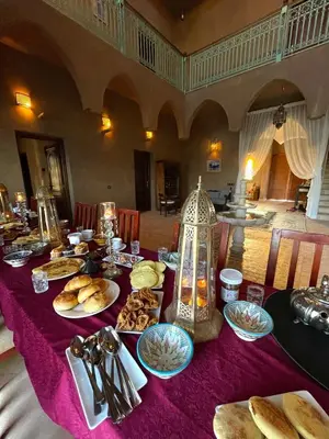 a table with a purple table cloth with food on it at Dar Amali, villa spacieuse 9ch avec piscine en exclusivité in Marrakech