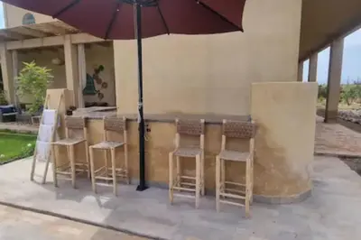 a bar with chairs and an umbrella on a patio at Dar Amali, villa spacieuse 9ch avec piscine en exclusivité in Marrakech