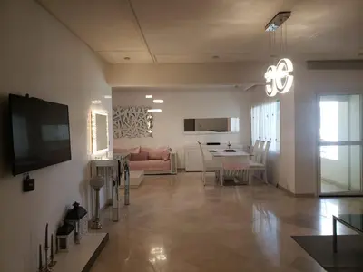 a living room with a couch and a dining room at Luxurious apartment city center in Fès