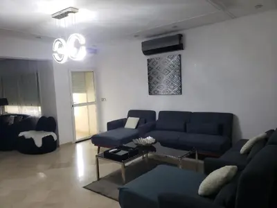 a living room with a blue couch and a table at Luxurious apartment city center in Fès