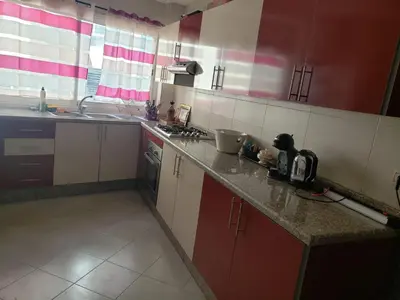 a kitchen with red and white cabinets and a sink at Luxurious apartment city center in Fès
