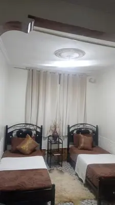 a bedroom with two beds and a ceiling at Amina appartement in Azrou