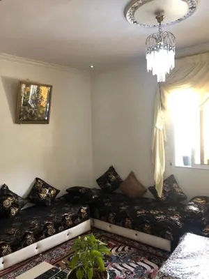 a bedroom with a bed with pillows and a chandelier at Amina appartement in Azrou