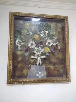 a picture of flowers in a picture frame on a wall at Amina appartement in Azrou