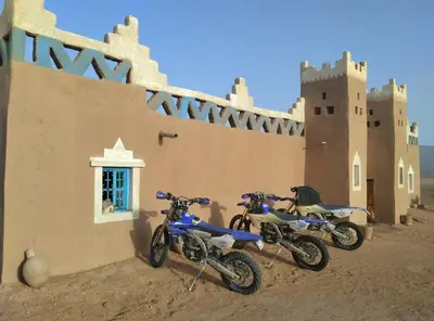 two motorcycles parked in front of a building at AUBERGE SAHARA IRIKI & Désert Tours in Foum Zguid