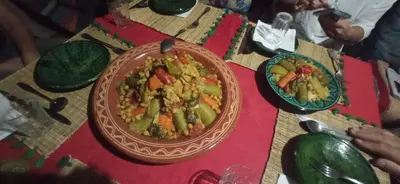 a table with a bowl of food and a plate of food at AUBERGE SAHARA IRIKI & Désert Tours in Foum Zguid