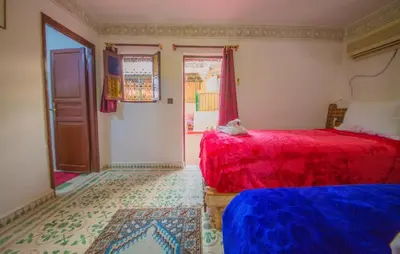 a bedroom with two beds and a door to a room at Riad Basma Fes - Tranquil Getaway in Fès
