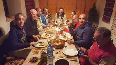 a group of people sitting around a table eating food at Auberge Ibrahim in Agoudal