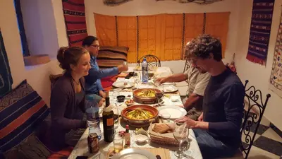 a group of people sitting around a table with food at Auberge Ibrahim in Agoudal