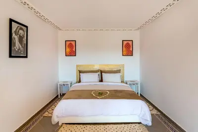 a bedroom with a bed and two tables at Villa Leila Farmhouse in Marrakech