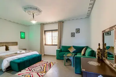 a bedroom with a green couch and a bed at Villa Leila Farmhouse in Marrakech