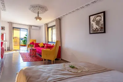 a bedroom with a bed and a living room with a couch at Villa Leila Farmhouse in Marrakech