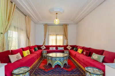 a living room with a red couch and a table at Villa Leila Farmhouse in Marrakech