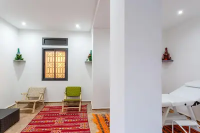a room with chairs and a table and a rug at Villa Leila Farmhouse in Marrakech
