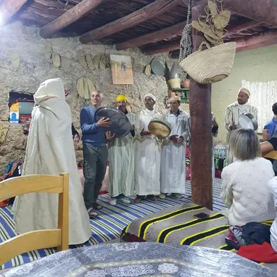 a group of people standing in a room with a priest at Gite Skoura in Caïd Bou Malla