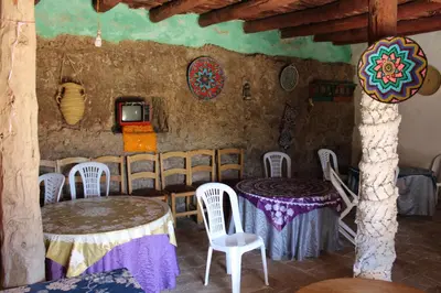 a room with two tables and chairs and a tv at Gite Skoura in Caïd Bou Malla