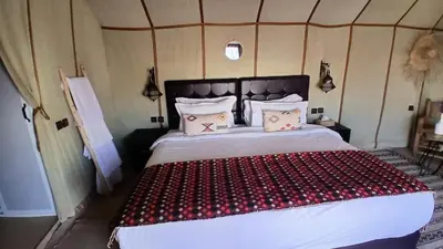 a bedroom with a large bed in a tent at Sunshine luxury desert camp in Merzouga