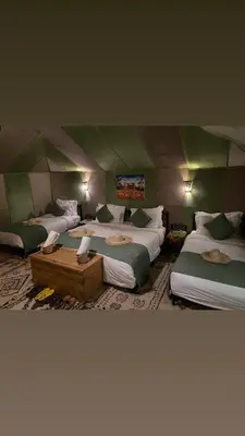 a room with three beds in a tent at Sunshine luxury desert camp in Merzouga