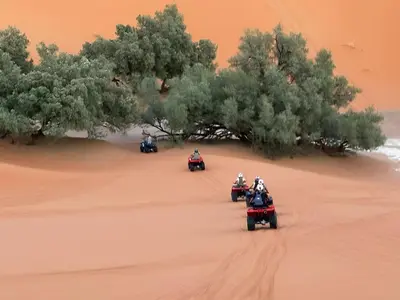 a group of people riding motorcycles in the desert at Sunshine luxury desert camp in Merzouga