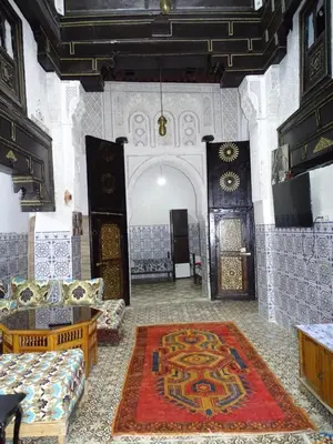 a living room with couches and a rug at Riad Amimi Fes in Fès